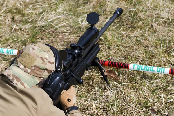 Military sniper aims at a target