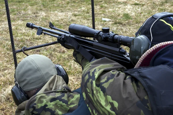 Military sniper aims at a target