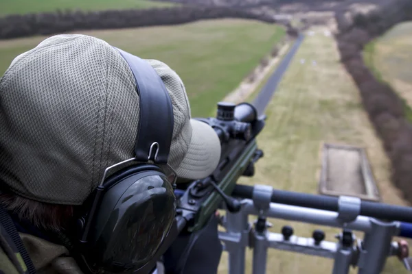 Military sniper aims at a target