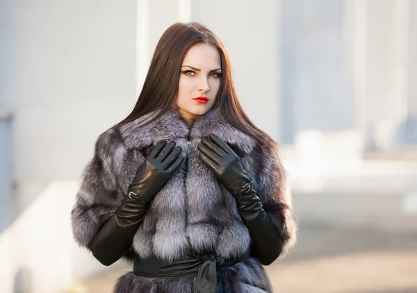 Woman fur coat and black leather gloves