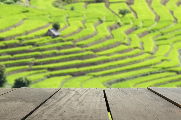 Defocus and blur image of terrace wood and beautiful perspective scenery rice terrace field for background usage