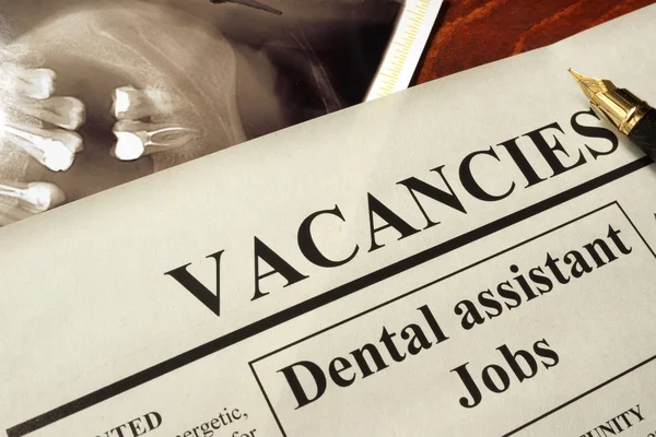Newspaper with ads dental assistant jobs vacancy.