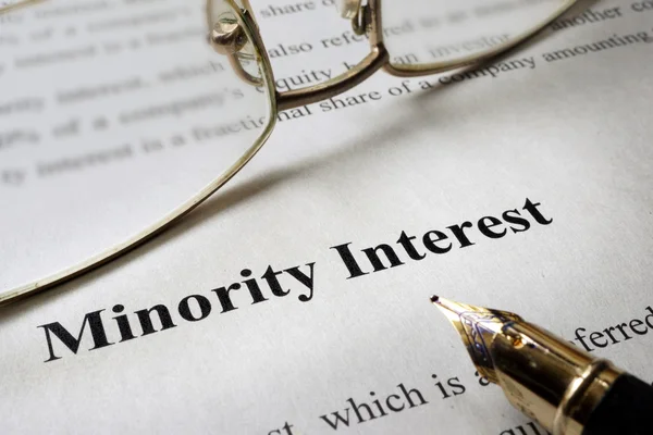 Sign minority interest on a paper and glasses.