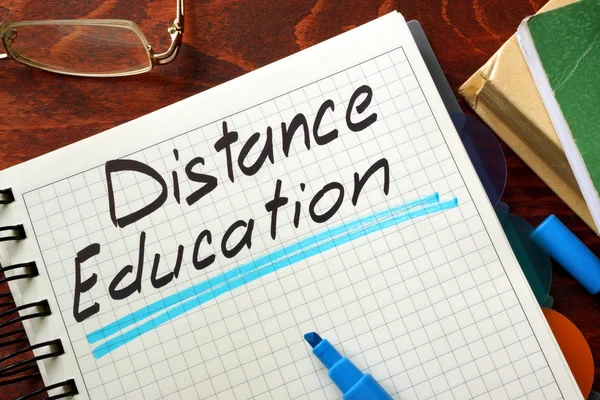 Sign distance education written in a notepad on a table.