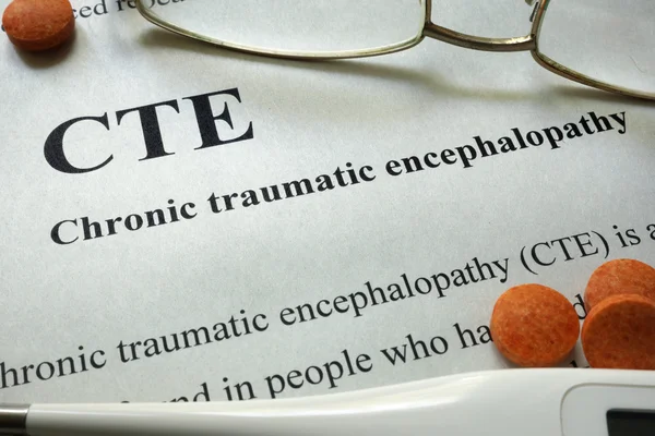 Paper with words CTE, Chronic Traumatic Encephalopathy  and glasses. Medical concept.