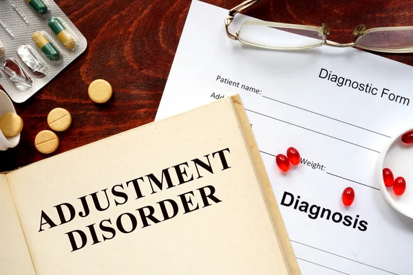 Adjustment disorder written on a book and diagnosis form.