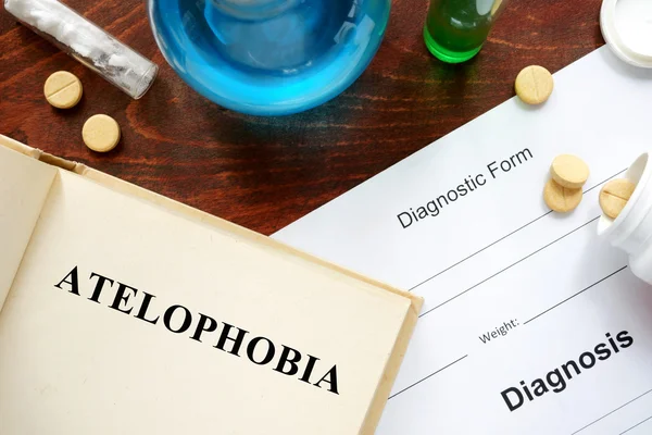 Atelophobia  written on a book and diagnosis form.