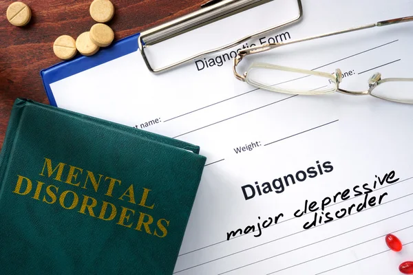 Major depressive disorder concept. Diagnostic form and book on a table.