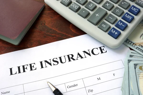 Life insurance form and dollars on the table.