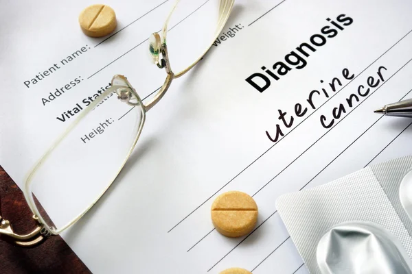 Diagnosis uterine cancer written in the diagnostic form and pills.
