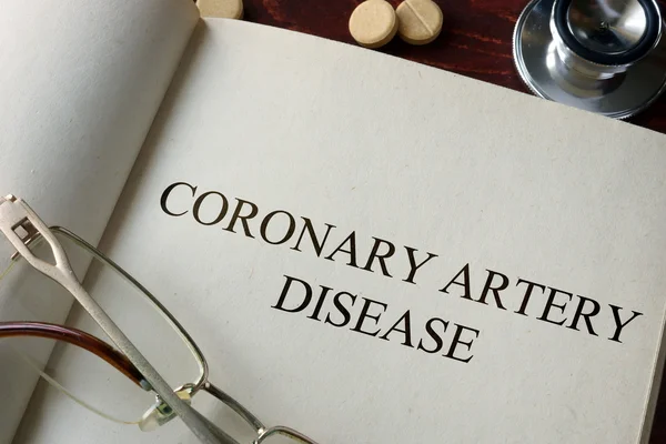 Book with diagnosis coronary artery disease and pills.