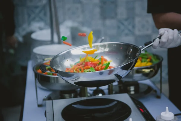 Cooking vegetables in wok pan