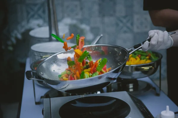 Cooking vegetables in wok pan