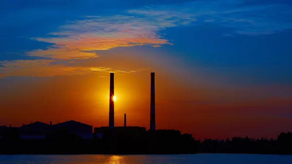 Factory in silhouette and sunrise sky
