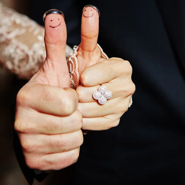 Wedding rings on her fingers painted with the bride and groom