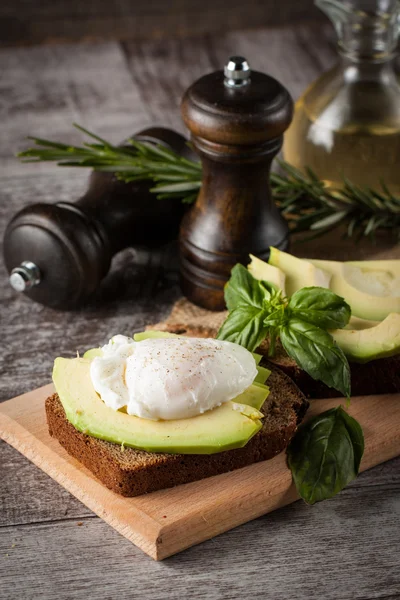 Healthy sandwich with avocado and poached eggs. Healthy food and diet concept.