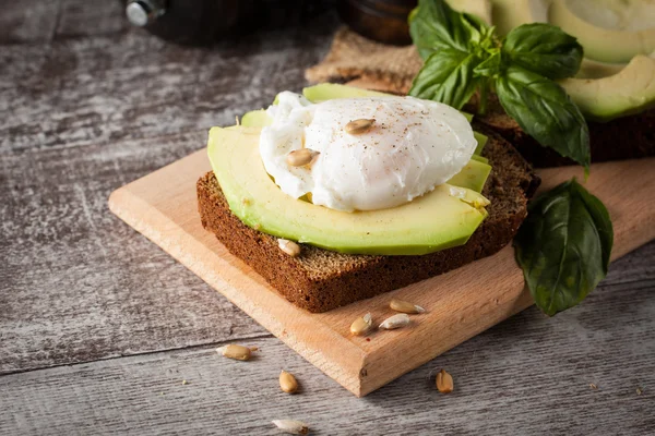 Healthy sandwich with avocado and poached eggs. Healthy food and diet concept.