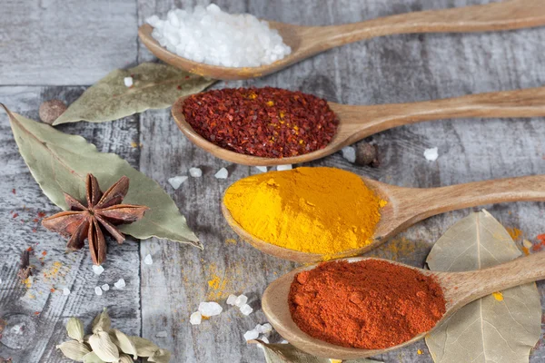 Spices. Spice in Wooden spoon. Herbs. Curry, Saffron, turmeric, cinnamon and other on a wooden rustic background. Pepper. Large collection of different spices and herbs. Salt, paprika.