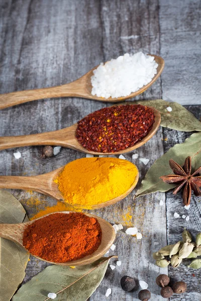 Spices. Spice in Wooden spoon. Herbs. Curry, Saffron, turmeric, cinnamon and other on a wooden rustic background. Pepper. Large collection of different spices and herbs. Salt, paprika.