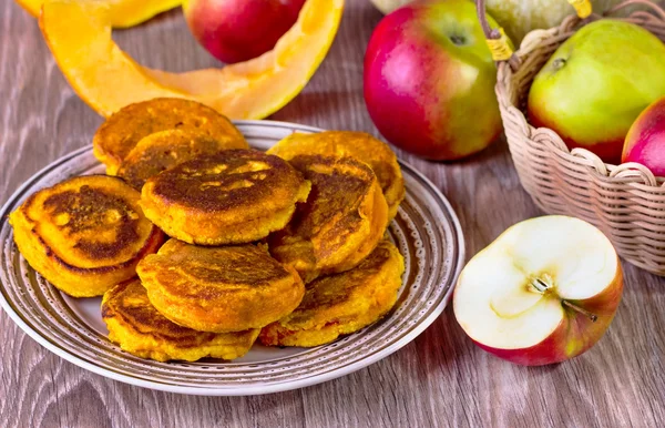 Fritters with pumpkin and apples on a beige plate