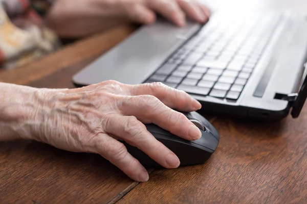 Senior hand using the mouse of a computer