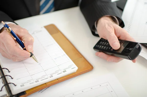 Businessman taking an appointment in his diary