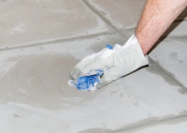 Tiler cleaning tiles after filling up joints