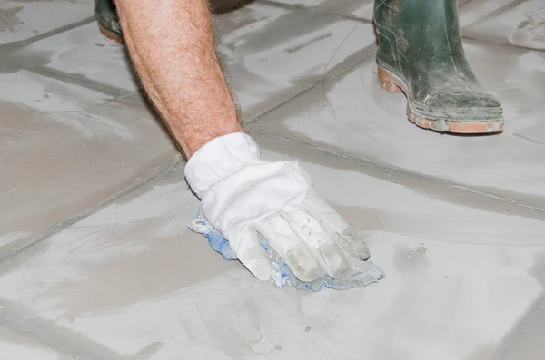 Tiler cleaning tiles after filling up joints