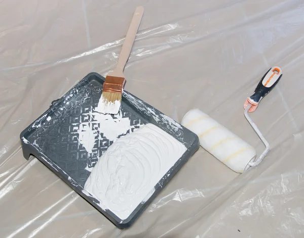 Paint tray with a paint brush and a roller