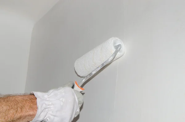 Hand painting a wall with a paint roller