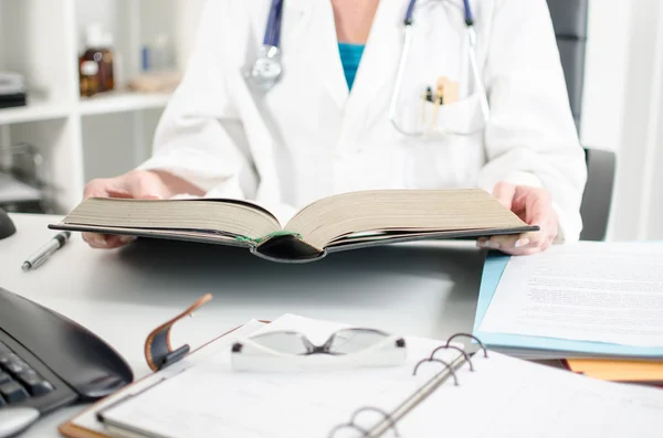 Female doctor reading a medical book