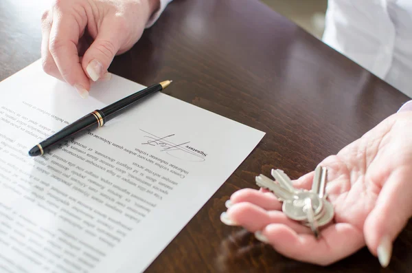 Woman holding house keys after contract signature