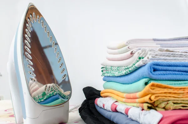 Iron and ironed linen on a ironing board