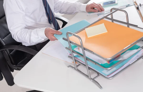 Businessman taking a record of his paper tray