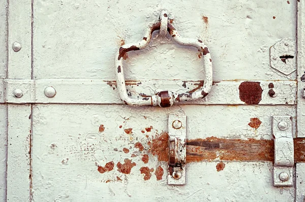 Aged steel door with peeling paint and rusty architectural details