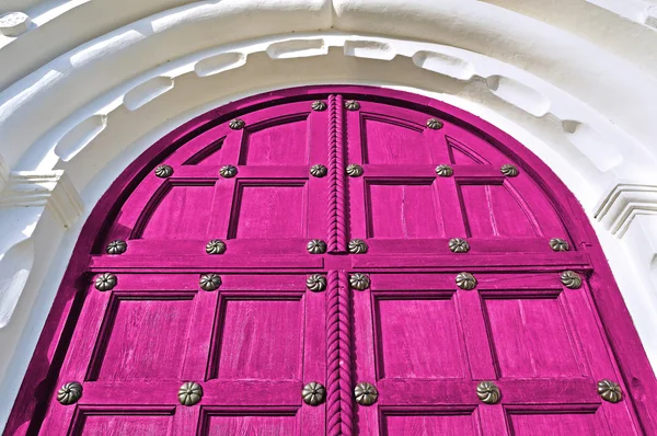 Architecture detailed background - aged wooden door of magenta color