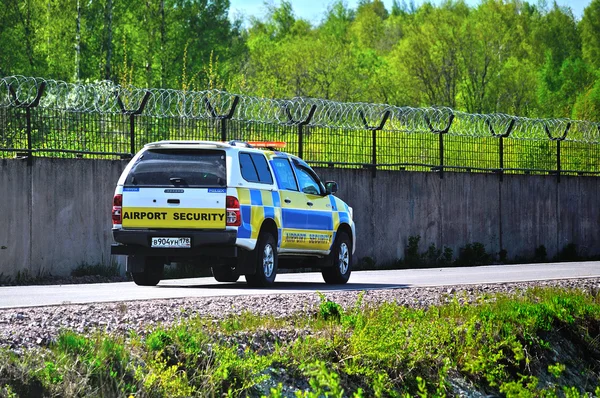 Airport security car is riding along the fence surrounding the runway of Pulkovo International Airport