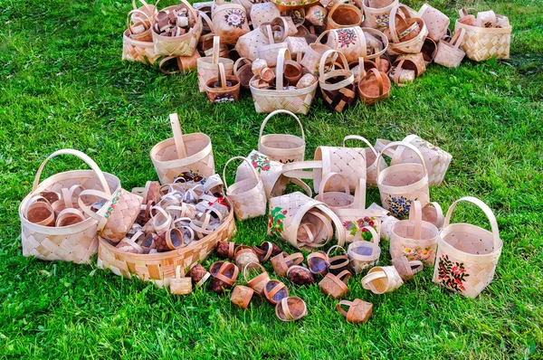 Russian wooden hand-woven baskets with patterns lying on the grass in the Craft Fair on City Day, Veliky Novgorod, Russia