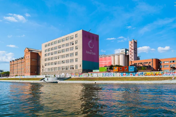 Business and industrial buildings with banner of Ring of Urals commercial bank on the embankment of Iset river, Yekaterinburg, Russia
