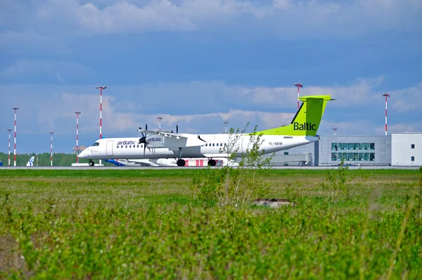 Air Baltic Airlines Bombardier Dash 8 airplane is riding on the runway after arrival in Pulkovo International airport in Saint-Petersburg, Russia