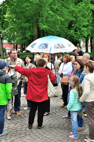 Female tour guide telling and showing tourists something in Peter and Paul Fortress in Saint-Petersburg, Russia