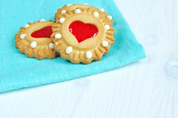 Some butter shortbread cookies stuffed with red heart shaped jelly - romantic background with free space for text.