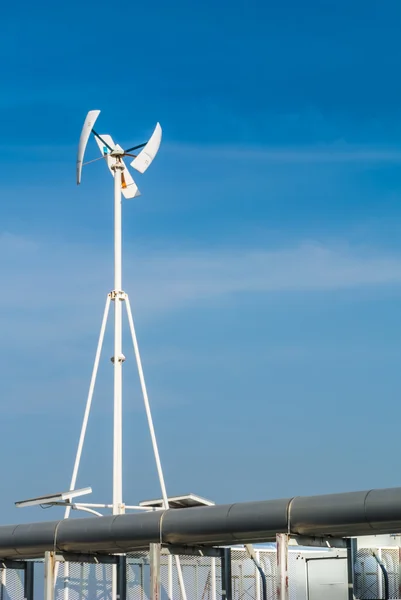 Vertical wind turbine on factory roof.