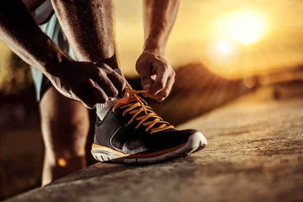 Man tying jogging shoes