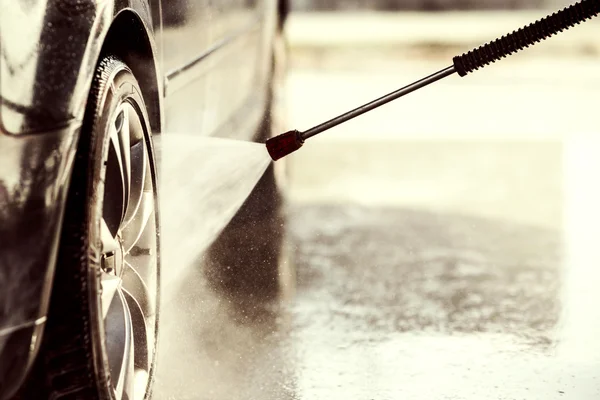 Cleaning the car with high pressure washer