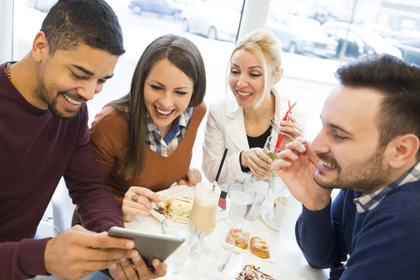 Happy young people having fun in a cafe,eating cake