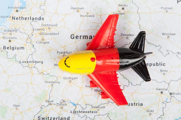 Close up of airplane toy with german flag, landed on the europe map. Travel concept