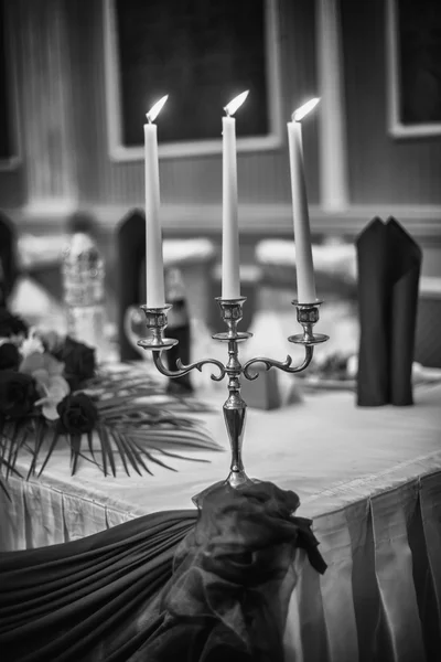 Vintage candlestick with burning candles on black and white