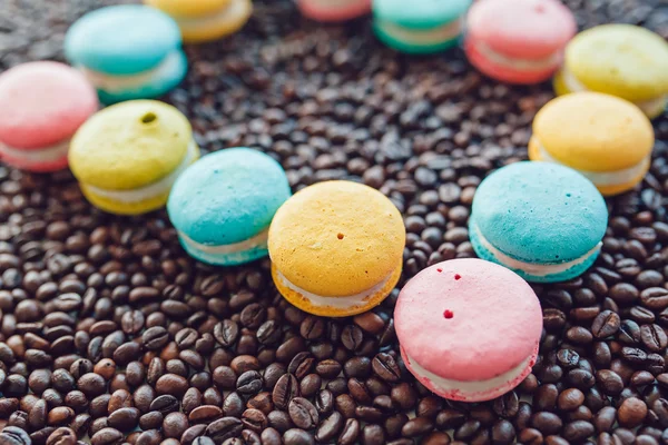 French macaroons laid out in a square on coffee beans background