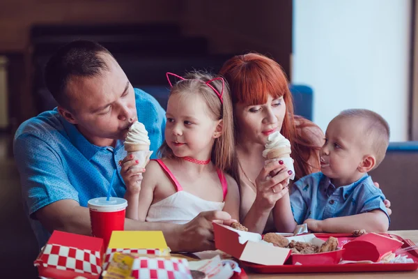 Happy family eating ice cream in restaurant